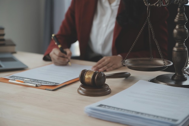 Business and lawyers discussing contract papers with brass scale on desk in office Law legal services advice justice and law concept picture with film grain effect