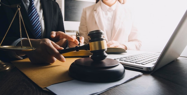 Business and lawyers discussing contract papers with brass scale on desk in office Law legal services advice justice and law concept picture with film grain effect