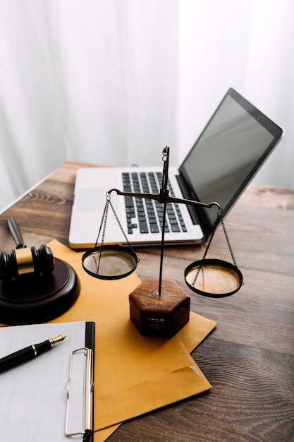 Business and lawyers discussing contract papers with brass scale on desk in office Law legal services advice justice and law concept picture with film grain effect