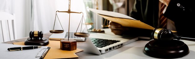 Business and lawyers discussing contract papers with brass scale on desk in office Law legal services advice justice and law concept picture with film grain effect