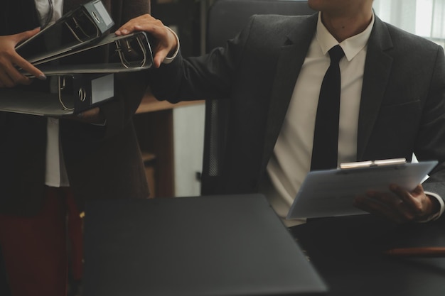 Business and lawyers discussing contract papers with brass scale on desk in office Law legal services advice justice and law concept picture with film grain effect