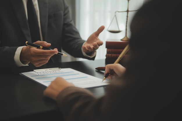 Business and lawyers discussing contract papers with brass scale on desk in office Law legal services advice justice and law concept picture with film grain effect