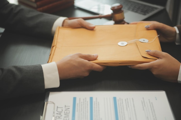 Business and lawyers discussing contract papers with brass scale on desk in office Law legal services advice justice and law concept picture with film grain effect