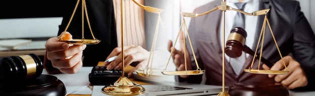 Business and lawyers discussing contract papers with brass scale on desk in office Law legal services advice justice and law concept picture with film grain effect