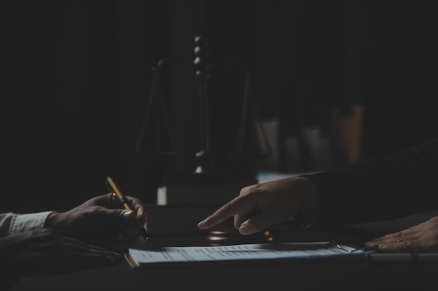 Business and lawyers discussing contract papers with brass scale on desk in office Law legal services advice justice and law concept picture with film grain effect