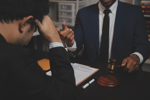 Business and lawyers discussing contract papers with brass scale on desk in office Law legal services advice justice and law concept picture with film grain effect