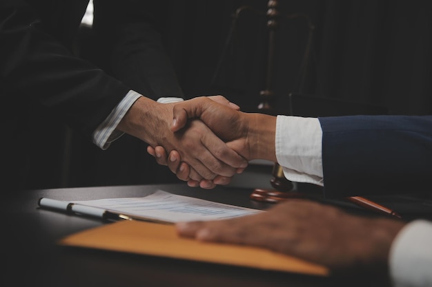 Business and lawyers discussing contract papers with brass scale on desk in office Law legal services advice justice and law concept picture with film grain effect