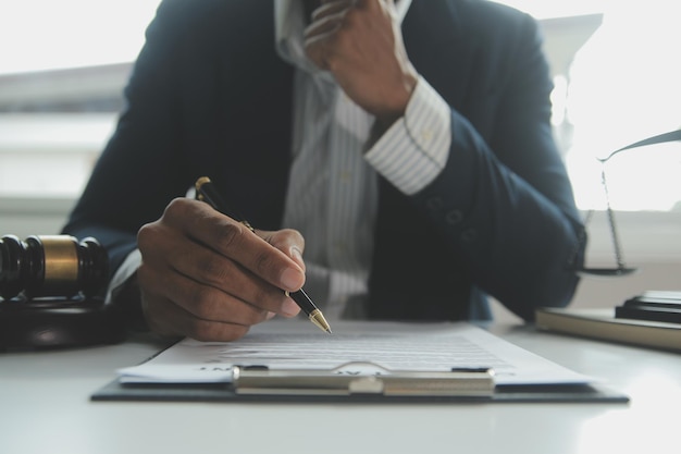 Business and lawyers discussing contract papers with brass scale on desk in office Law legal services advice justice and law concept picture with film grain effect