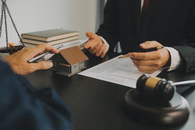 Business and lawyers discussing contract papers with brass scale on desk in office Law legal services advice justice and law concept picture with film grain effect