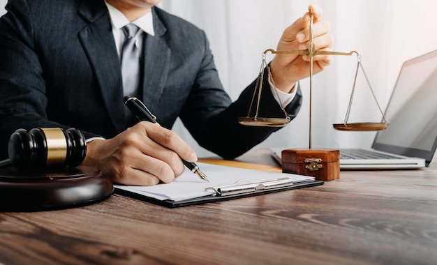 Business and lawyers discussing contract papers with brass scale on desk in office Law legal services advice justice and law concept picture with film grain effect