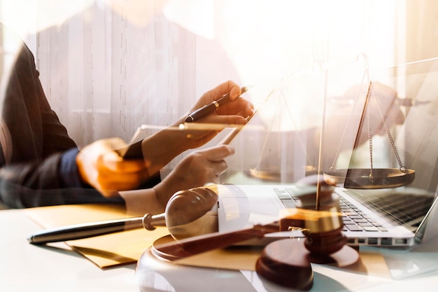 Business and lawyers discussing contract papers with brass scale on desk in office Law legal services advice justice and law concept