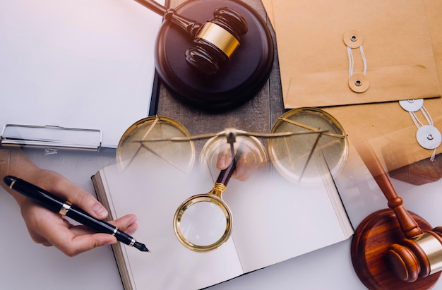 Business and lawyers discussing contract papers with brass scale on desk in office Law legal services advice justice and law concept