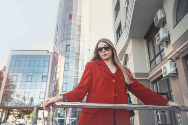 A business literate talented business woman is talking on a mobile phone on the background of a business center Portrait of a business woman The woman is the boss Business style