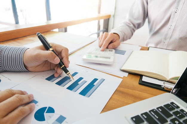 Business man analysis data document with accountant calculating about fee tax at a office