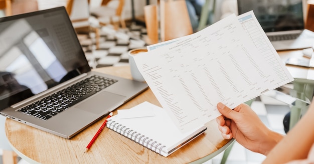 Business man checks information in charts in office near laptop