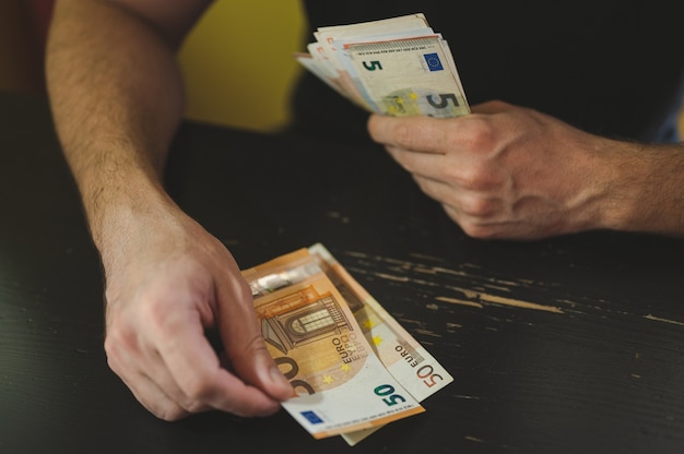 Business man counting money. rich male hands holds and count cash banknotes of 50 euros bills or notes currency