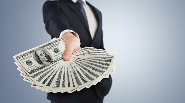 Business Man Displaying a Spread of Cash over a green vintage background