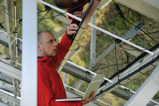 business man  engineer using laptop at solar panels plant eco energy field  in background