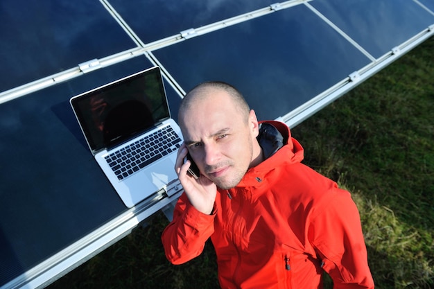 business man  engineer using laptop at solar panels plant eco energy field  in background