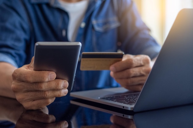 Business man hand using mobile phone and credit card for online shopping and payment