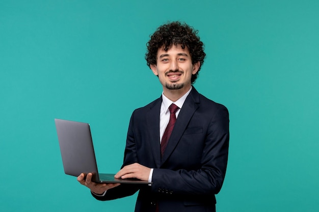 Business man handsome cute young guy in black suit and red tie smiling and holding a computer