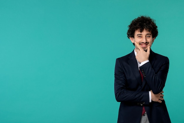 Business man handsome cute young guy in black suit and red tie smiling with the hand on chin