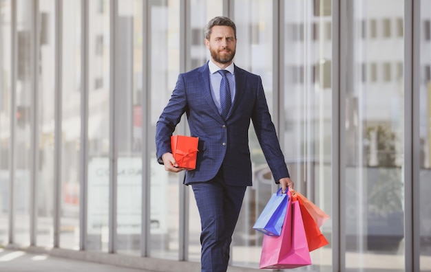 Business man holding shopping bags and walking in shopping store shopping and paying shopaholic shop