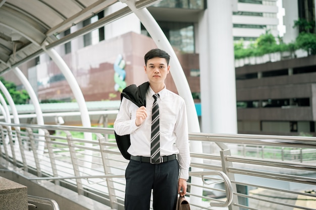 A business man is wearing a black suit, white shirt and necktie.