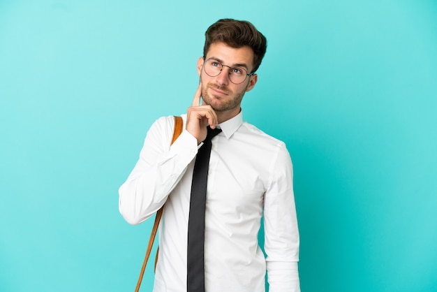 Business man over isolated background thinking an idea while looking up