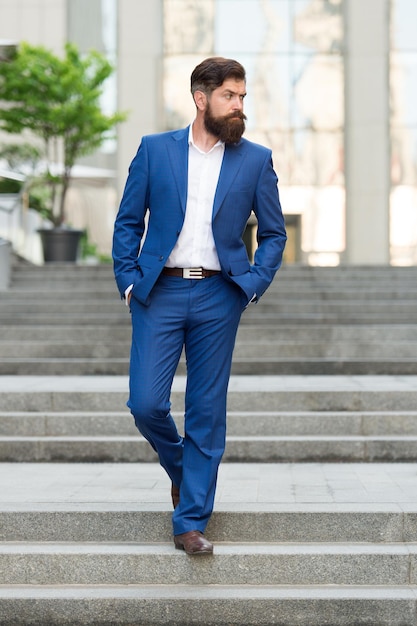 Business man in modern city Beginning of working day Motivated for success Office worker confidently step on stairs Founder successful business Conquer business world Bearded man going to work