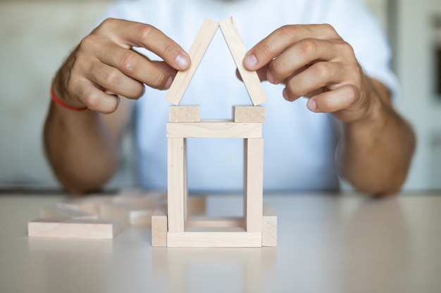 Photo business man placing wooden block on a tower concept risk control, planning and strategy in business. alternative risk concept,risk to make buiness growth concept with wooden blocks