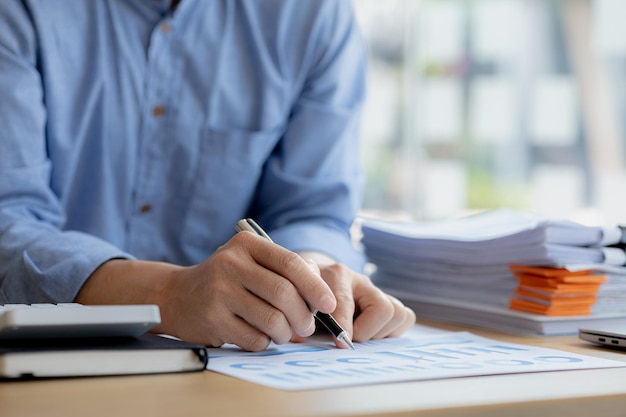 Business man pointing to a chart document showing company financial information He sits in a private office a document showing company financial information in chart form Financial concepts