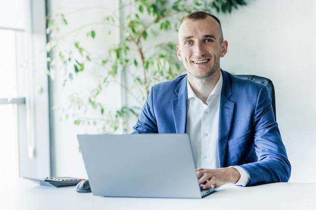 Business man portrait working on a laptop in an office