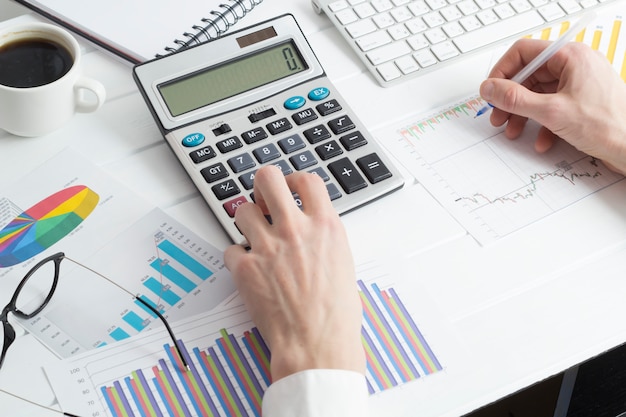 Business man prepares a financial report working with a calculator. 