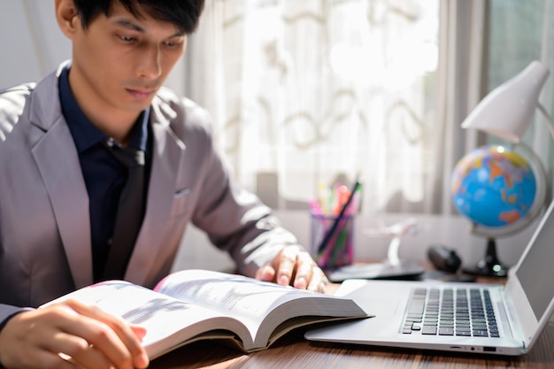 Business man reading a book at his desk