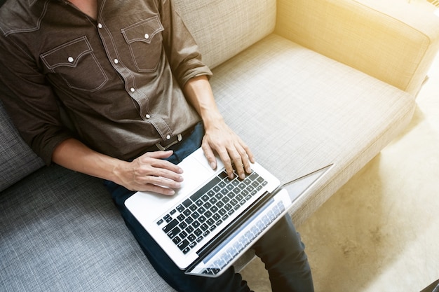 Business man in relax casual form working with laptop sitting on sofa at office 