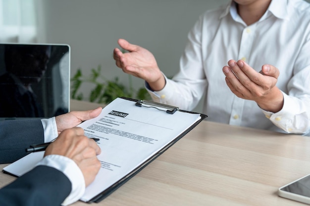 A business man's hand holding a resume The management is taking the exam Candidate job interview Resume concept