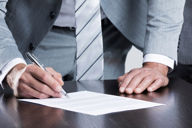 Business man sign contract standing near the table