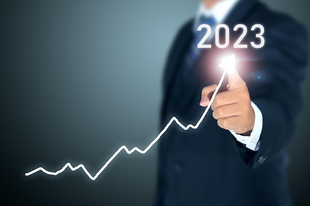 business man signing 2023 profit graph