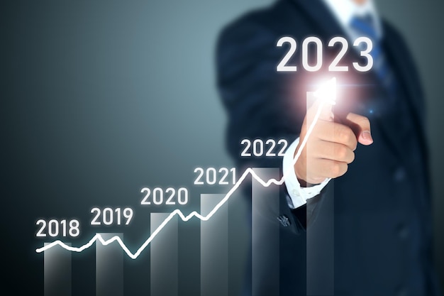 business man signing 2023 profit graph