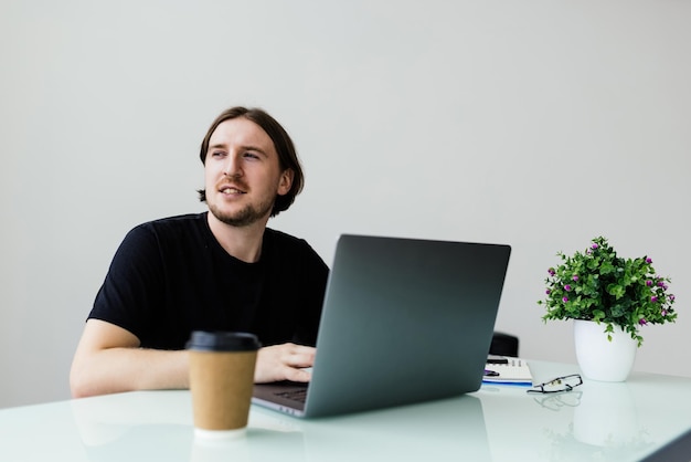 Business man sitting at office desk working on laptop computer