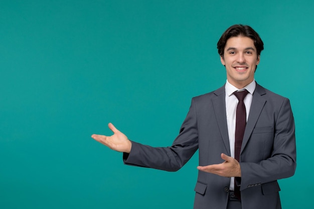 Business man stylish cute handsome man in grey office suit and tie smiling and pointing to left