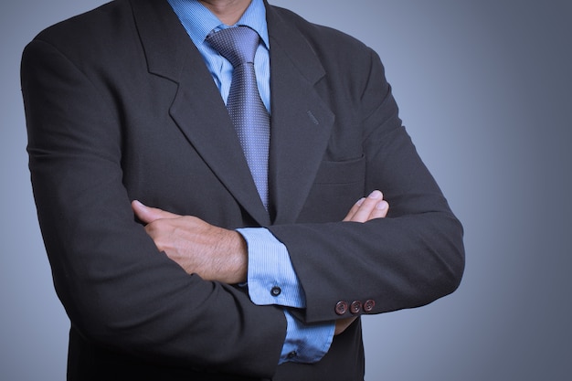 business man in a stylish suit standing with folded arms