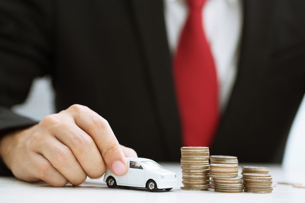 Photo business man in suit and close up hand holding model of toy car