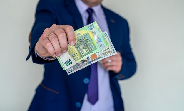 Business man in suit holding euro and dollar banknote for exchange rate