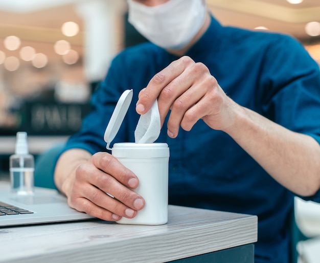 business man using antiseptic wipes sitting at the table