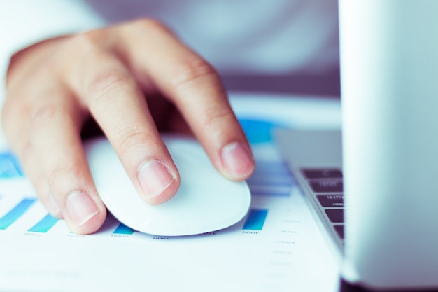 business man using a mouse working on laptop computer