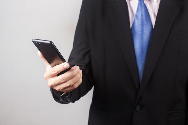 Business man using smart phone on gray background