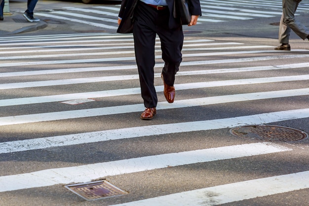 Business man walks on a pedestrian crossing