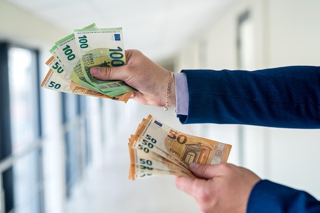 Business man wear suit giving euro banknotes in office